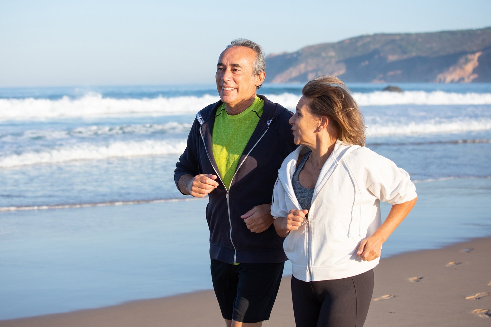 happy senior couple running along ocean coast summer day medium shot smiling caucasian man woman taking care health having cardio training family sport concept Traumatologo Ortopedista en Tijuana https://drcisnerosortopedia.com
